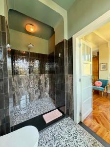 a bathroom with a shower with black tile at Villa Lou in Toscolano Maderno +44 photos