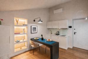 a kitchen with a table and chairs in a room at Altrove Boutique Studios in Caserta