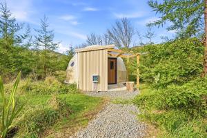 a small shed in the middle of a field at Takahuri Glamping Domes in Whanganui