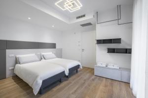 a white bedroom with a large bed and white walls at el Zhìgol B&B in Farra di Soligo