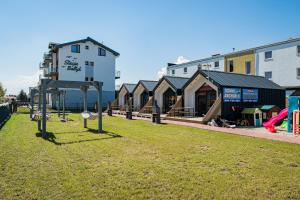 a park with a playground with a building at Domki Anchor II - 200m od Morza, Klimatyzacja, Plac Zabaw, Parking in Karwia