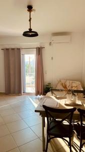 a dining room with a table and chairs and a window at Niko's apartments 1 in Elafonisos