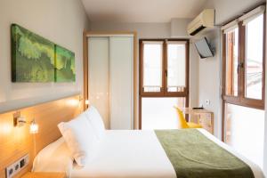 a hotel room with a bed and a window at Hotel Olatu in Zarautz