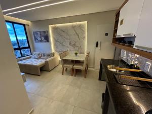 a kitchen and living room with a table and a couch at Apartamento Max Derby Boulevard in Recife