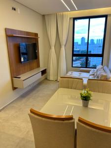 a room with a table and chairs and a large window at Apartamento Max Derby Boulevard in Recife