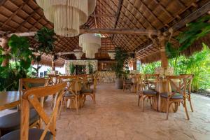 a restaurant with wooden tables and chairs and plants at La Gracia Hotel & Spa in San Jerónimo