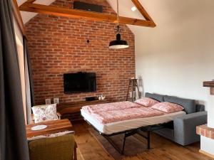 a bedroom with a bed and a brick wall at Iža na brejgi in Moravske-Toplice