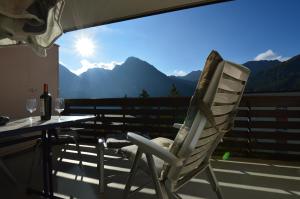 a white rocking chair sitting on a balcony with a table at Gentiana C7 in Arosa