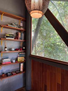 a room with a window and a shelf with books at Chalé cercado pela natureza in Imbituba