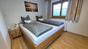 a bedroom with a wooden bed and a window at Apart-Alpenglück in Biberwier