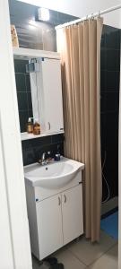 a bathroom with a sink and a shower curtain at Sobe i apartmani "Terasa" in Smederevo