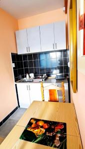 a kitchen with a wooden table in a kitchen at Sobe i apartmani "Terasa" in Smederevo