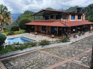 a house with a swimming pool in front of it at villa veronica in Sasaima