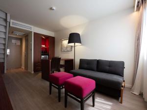a living room with a couch and pink seats at Mercure Perpignan Centre in Perpignan