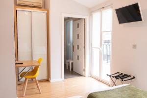 a bedroom with a desk and a yellow chair in a room at Hotel Olatu in Zarautz +50 photos