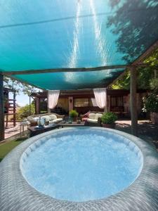 a large swimming pool with a blue roof at La Baita Suite in Sicignano degli Alburni