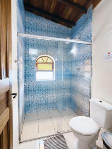 a bathroom with a toilet and a shower with blue tiles at Geko Pousada Paraty in Paraty