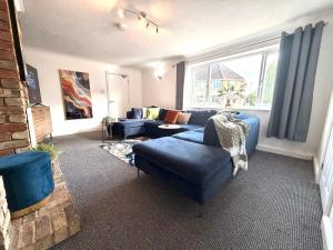 a living room with a blue couch and a window at Swan View House in Littleport
