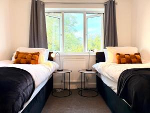 two beds in a room with a window at Swan View House in Littleport