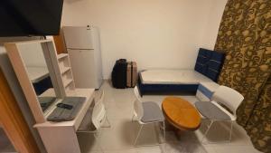 a small room with a bed and a table and a refrigerator at Relaxing bed Ajman in Ajman 