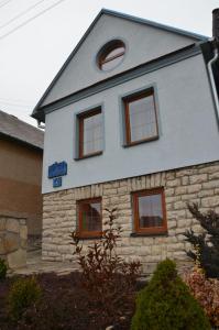 a stone house with a gray roof and windows at Chata Horec in Štrba