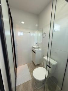 a white bathroom with a toilet and a shower at Riovale Container Lofts in Petrolina