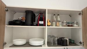 a cupboard filled with dishes and appliances at Ticallisti Rooms by Villa Lagkadaki in Agriliá