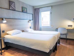 a hotel room with a large bed and a window at Ibis Agen Centre - Rénové en 2026 in Agen