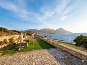a view of the ocean with a couch and an umbrella at Ticallisti Rooms by Villa Lagkadaki in Agriliá