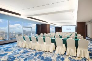 a conference room with a long table and white chairs at Changsha Rama-da by Wyndham Wuyi Square-Near Metro-Business Center in Changsha +25 photos