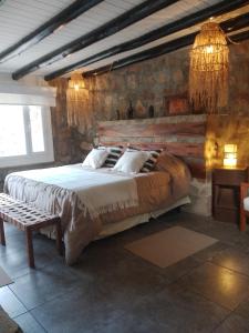 a bedroom with a large bed in a stone wall at Oveja Mansa in La Cumbre
