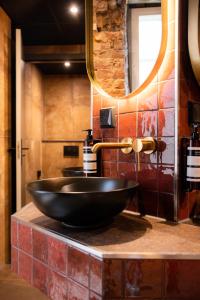 a bathroom with a black sink and a mirror at Kumo Hostels in Groningen +18 photos