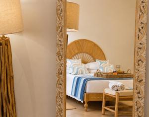 a bedroom with a bed and a large mirror at LIGEA APARTMENT - Bright Mediterranean Home with Bali-Inspired Touches - Central Anzio near Sea, Train and Bus Station in Anzio