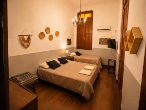 a bedroom with two beds and a tv in it at A la Gurda Hostel - Barrio Norte in San Miguel de Tucumán
