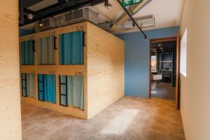 a room with a wall of windows and a hallway at Kumo Hostels in Groningen