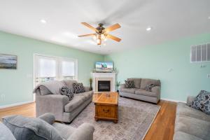 a living room with two couches and a ceiling fan at Fairway Stay in Greenbackville