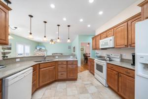 a large kitchen with wooden cabinets and white appliances at Fairway Stay in Greenbackville