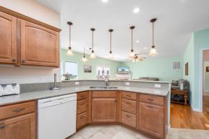 a kitchen with wooden cabinets and a white dishwasher at Fairway Stay in Greenbackville