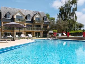a swimming pool in front of a hotel at Mercure Bayeux Omaha Beach in Port-en-Bessin-Huppain