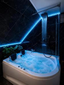 a bathroom with a tub with blue lights on it at Luxor - Private Jacuzzi Boulevard Suites in Sibiu +76 photos