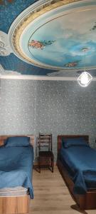 a bedroom with two beds and a painting on the wall at Nino in Kaspi