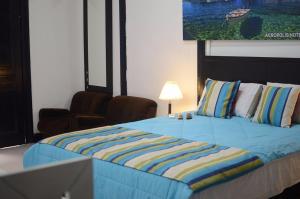 a bedroom with a bed with a blue comforter at Hotel Acropolis Callao in Lima
