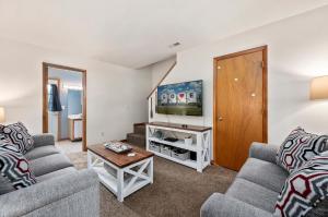 a living room with two couches and a tv at Fishhook Hideaway in Chincoteague