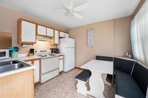 a kitchen with a table and a white refrigerator at Fishhook Hideaway in Chincoteague