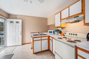 a kitchen with white appliances and a window at Fishhook Hideaway in Chincoteague +14 photos