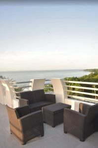 a group of chairs and tables on a balcony with the ocean at Tocopia and private house ddi in Sangre Grande