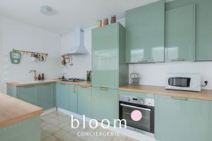 a kitchen with blue cabinets and a microwave at La maison de C Moench in Nancy
