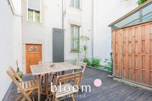 a wooden table and chairs on a patio at La maison de C Moench in Nancy