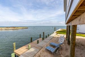 a dock with two blue chairs and the water at Gallops Point in Greenbackville