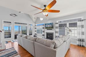 a living room with a couch and a ceiling fan at Gallops Point in Greenbackville +48 photos